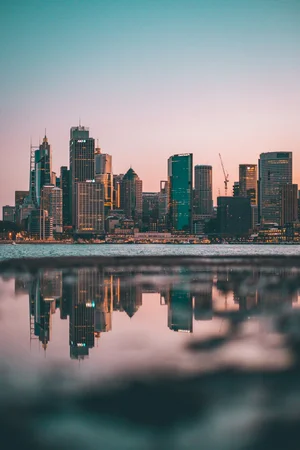 City skyline at sunset reflected in calm water